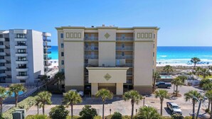 Un hotel de varios pisos con balcones, piscina y vista a la playa.