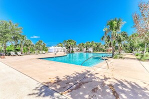 Una piscina con lettini e palme.