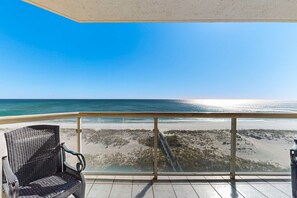 Ein Balkon mit Blick auf Strand und Meer.
