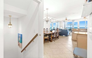 Eine moderne Küche mit Essbereich, Meerblick und einer Treppe zu einer weiteren Ebene.
