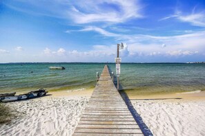 A wooden pier leading to a sandy beach with calm waters and a clear sky. - Bayview Condo with Shared Pool, Beach Nearby - Snowbirds Welcome (Pensacola Beach)