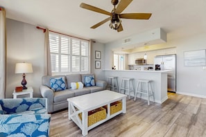 A living room with a sofa, a coffee table, and a ceiling fan. - Destin West Bayside Pelican 608 - Gorgeous bayside condo with lazy river and beach access (Fort Walton Beach)
