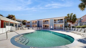 A swimming pool with a 3 FT depth limit, surrounded by a fence, and adjacent to a multi-story building with balconies. - Cozy Coastal Gulf Condo with Shared Pool and Beach Access (Pensacola Beach)