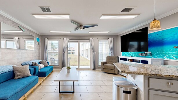 Una sala de estar moderna con un sofá azul, una mesa de centro y un televisor.