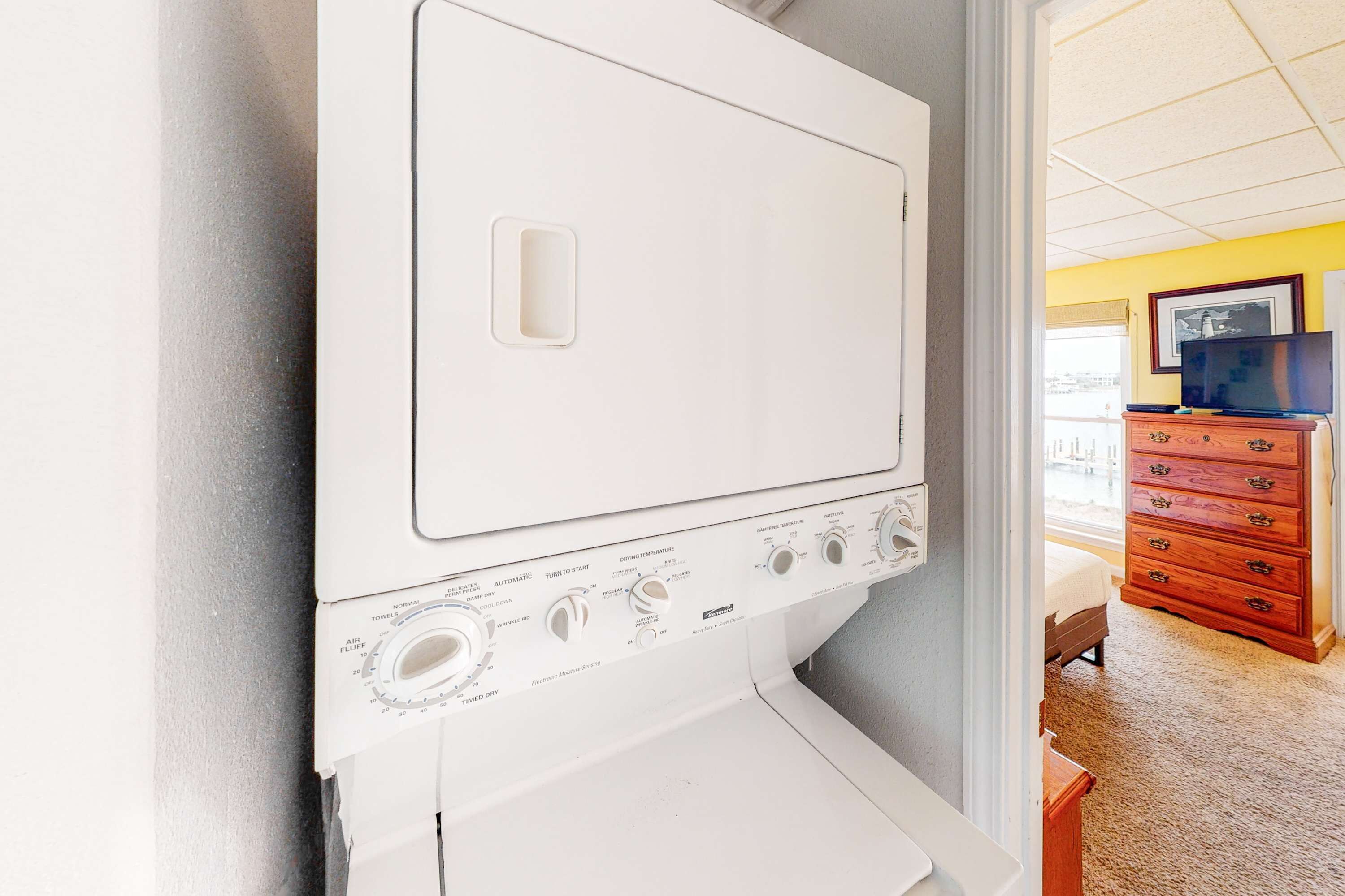 Une machine à laver à chargement frontal, dotée de boutons de commande et d’un compartiment de séchage.