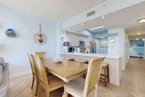 A kitchen with wooden cabinets, a white countertop, and a central island. - Comfortable and cozy beachfront condo w shared amenities (Fort Walton Beach)