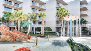Une cour d’hôtel agrémentée d’un élément aquatique, d’une grande statue de grenouille et d’une sculpture de bateau.