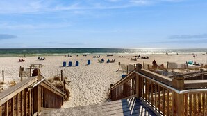 Une plage avec des passerelles en bois menant au rivage, une plage de sable et l’océan.