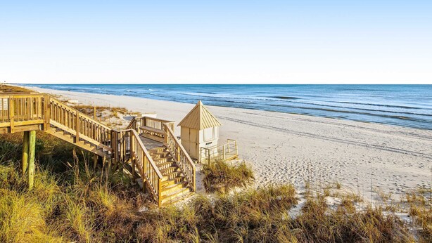 A wooden staircase leading to a beach area with a lifeguard tower. - Beachfront ground-floor condo with beach & Gulf views, outdoor pool & tennis (Miramar Beach)