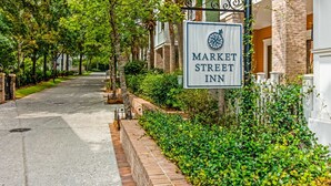 Letrero del Market Street Inn, un edificio de ladrillo con un jardín bien cuidado y un camino de entrada pavimentado.