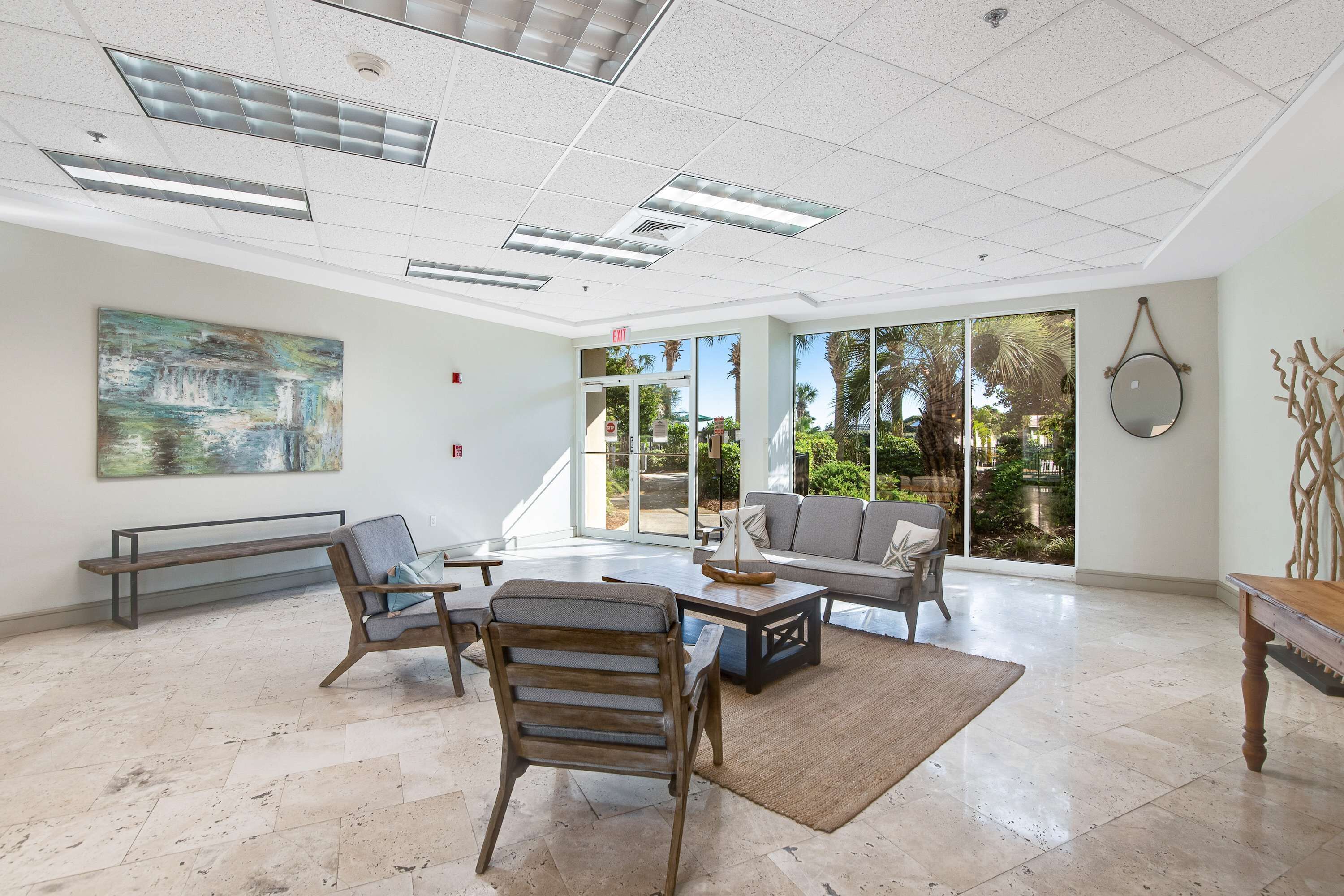 A spacious lobby with a large window, a bench, a sofa, and a coffee table.