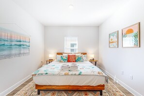 A bedroom with a bed, two bedside tables, a window, and wall art. - Heated community pool, themed kids room, dog friendly Beach, & Relaxing Massage (Port St. Joe)