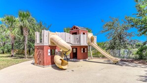 A playground with a slide and climbing structures. - Heated community pool, themed kids room, dog friendly Beach, & Relaxing Massage (Port St. Joe)