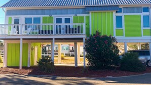 A two-story house with a balcony, green shutters, and a covered porch. - Dog-Friendly Florida Beach House Steps from the Water in Carrabelle (Carrabelle)