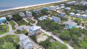 Un área residencial costera con casas, una playa y una vista despejada del océano.