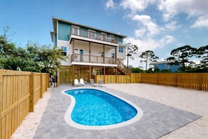 A two-story house with a swimming pool in the backyard. - Beautiful home near the water with scenic views and brand-new outdoor pool (Cape San Blas)