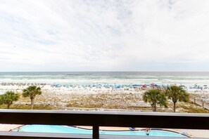 Blick auf einen Strand mit Pool und Strandstühlen.