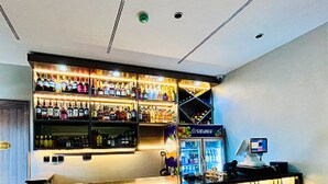 Eine Bar mit Regalen voller Spirituosenflaschen, einer Registrierkasse und einem Computermonitor.