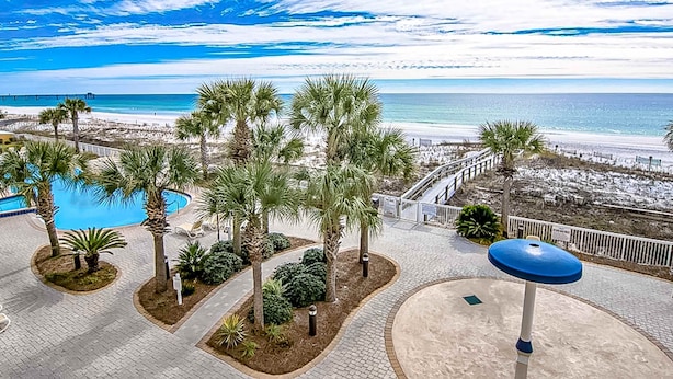 A resort with a pool, palm trees, and a beach view. - 4th-Floor Azure Condo with Free WiFi, Beach Service, Gulf View, Shared Pool,Hot Tub (Fort Walton Beach)