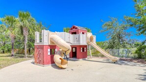 Ein Spielplatz mit Rutsche und Klettergerüsten.