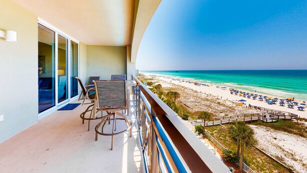 Ein Balkon mit Blick auf Strand und Meer.