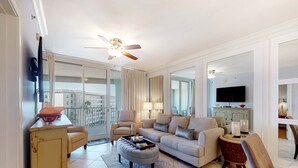 Una sala de estar moderna con un sofá, sillones, una mesa de centro y un televisor.