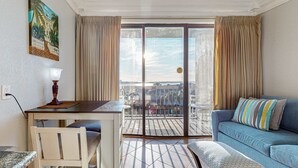 Una habitación con una mesa de comedor, un sofá y vistas al exterior a través de una puerta corrediza de vidrio.