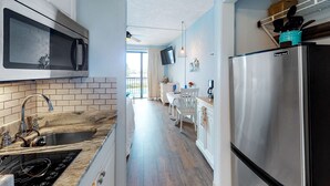 Una cocina moderna con un refrigerador de acero inoxidable, un microondas y un horno empotrado.