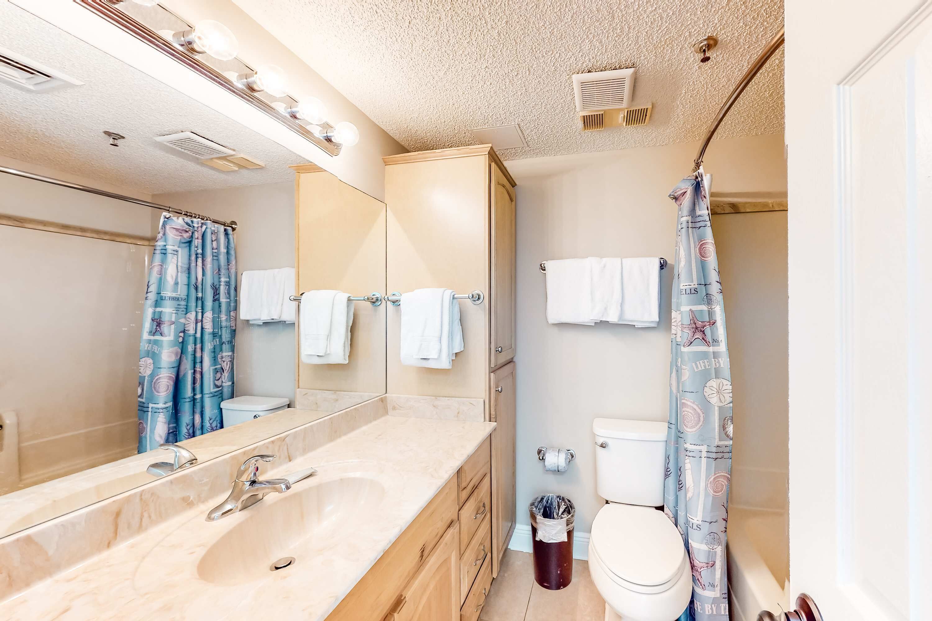 Un baño con dos lavamanos, un inodoro y una cortina de ducha.