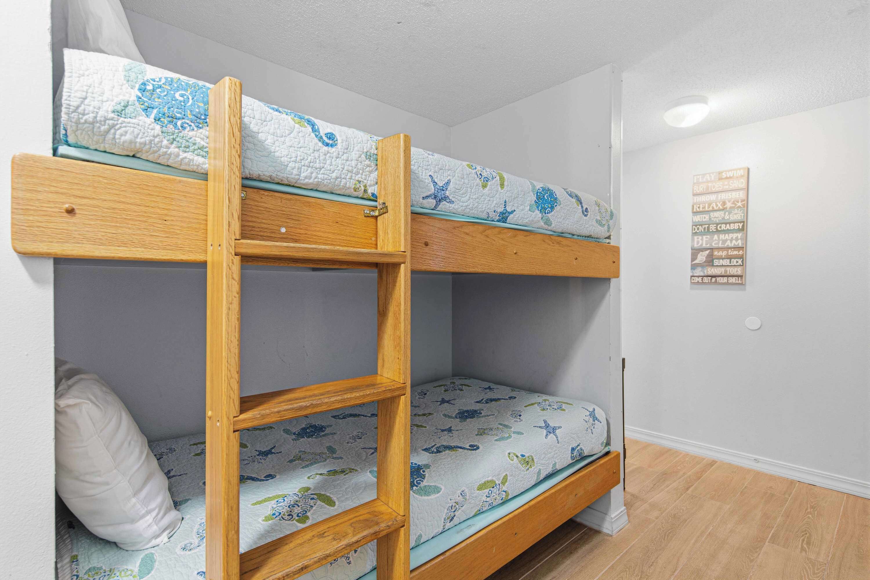 A bunk bed with a wooden frame and a mattress with a blue and white pattern.