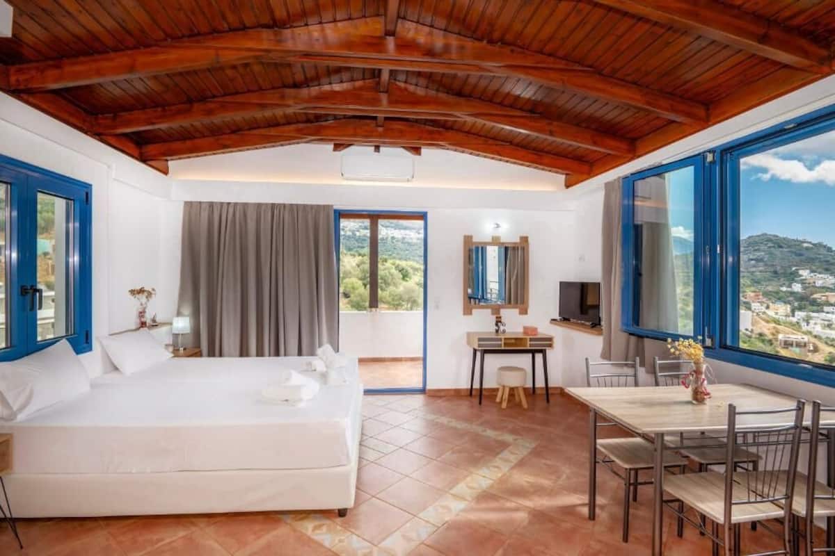 Un dormitorio con cama, escritorio y mesa de comedor.