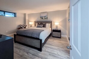 A modern bedroom with a bed, bedside tables, a bench, and a window. - Gulf front condo with Wifi, Wash and dryer, Rooftop pool (Fort Walton Beach)
