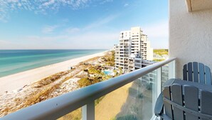 Ein Balkon mit Blick auf einen Strand und ein Hotelgebäude.