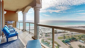 A balcony with a view of the beach and ocean, featuring a grill and seating area. - Waterfront condo with WiFi, washer/dryer, pools, fitness room, & beach access (Pensacola Beach)