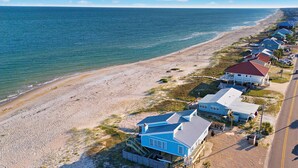 A coastal property with a beach view, a road, and multiple houses with distinct architectural styles. - Dog-friendly with Gulf view, pool, balcony, deck, fireplace, central AC, & W&D (St. George Island)