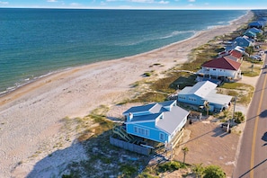 A coastal property with a beach view, a road, and multiple houses with distinct architectural styles. - Dog-friendly with Gulf view, pool, balcony, deck, fireplace, central AC, & W&D (St. George Island)