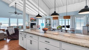 A spacious kitchen with white cabinets, a marble countertop, and pendant lighting. - Dog-friendly with Gulf view, pool, balcony, deck, fireplace, central AC, & W&D (St. George Island)