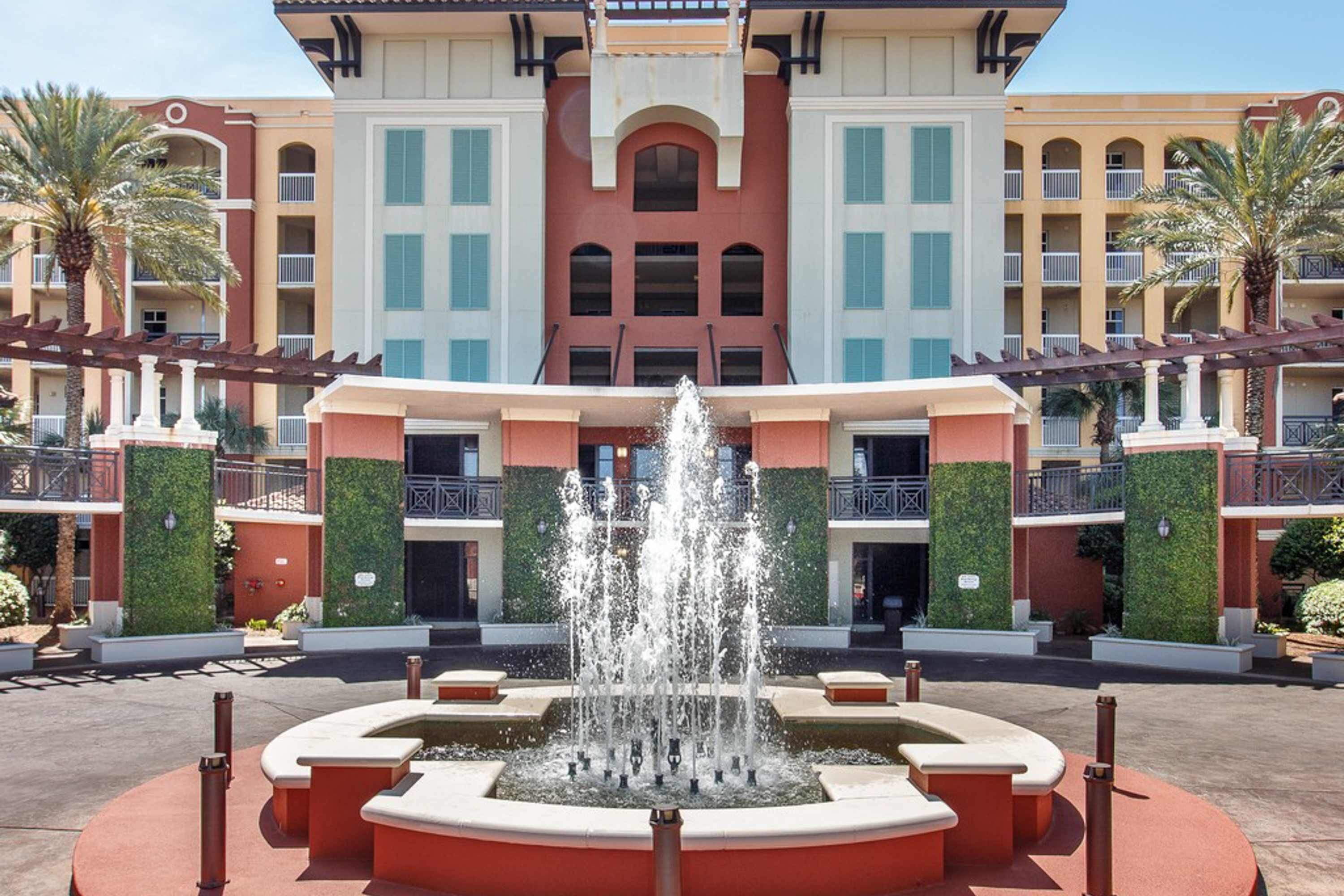 Ein Hotel mit einer zentralen Springbrunnen, mehreren Balkonen und einer symmetrischen Fassade.