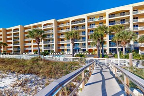A multi-story hotel with balconies, a pool area, and a wooden boardwalk leading to the beach. - Beautiful coastal retreat with water view, beach access, & shared pool,hot tub (Fort Walton Beach)