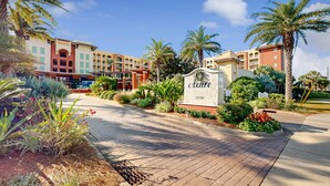 Een hotelentree met een bord waarop 'Azure 1150' staat, omgeven door aangelegde tuinen en palmbomen.