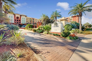A hotel entrance with a sign reading "Azure 1150," surrounded by landscaped gardens and palm trees. - Gulf Front Condo, Beach Service Included, Walk To Dining & Entertainment (Fort Walton Beach)