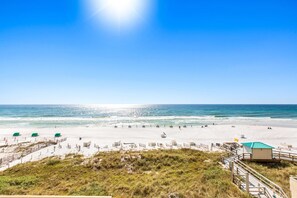 A beach with a clear sky, sandy shore, and a lifeguard station. - 5th floor condo w splash pad, multiple pools, and on-site bar (Destin)