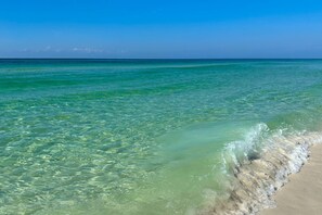 Ein Strand mit klarem türkisblauem Wasser und einem Sandstrand.