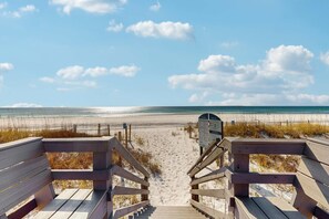 A wooden boardwalk leading to a sandy beach with a clear view of the ocean. - Beautiful seaside condo featuring a sparkling pool and direct beach access (Fort Walton Beach)