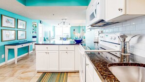 A modern kitchen with white cabinets, a granite countertop, and a stainless steel sink. - Beach front condo with washer&dryer, shared pool and beach access (Santa Rosa Beach)