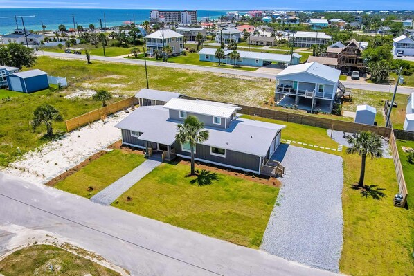 Zona residencial con casas, playa y una carretera.