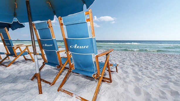 Beach chairs under a blue umbrella on a sandy beach with the ocean in the background. - Pretty Gulf Front Condo Fun Amenities, Nearby Shopping & Dining! (Fort Walton Beach)