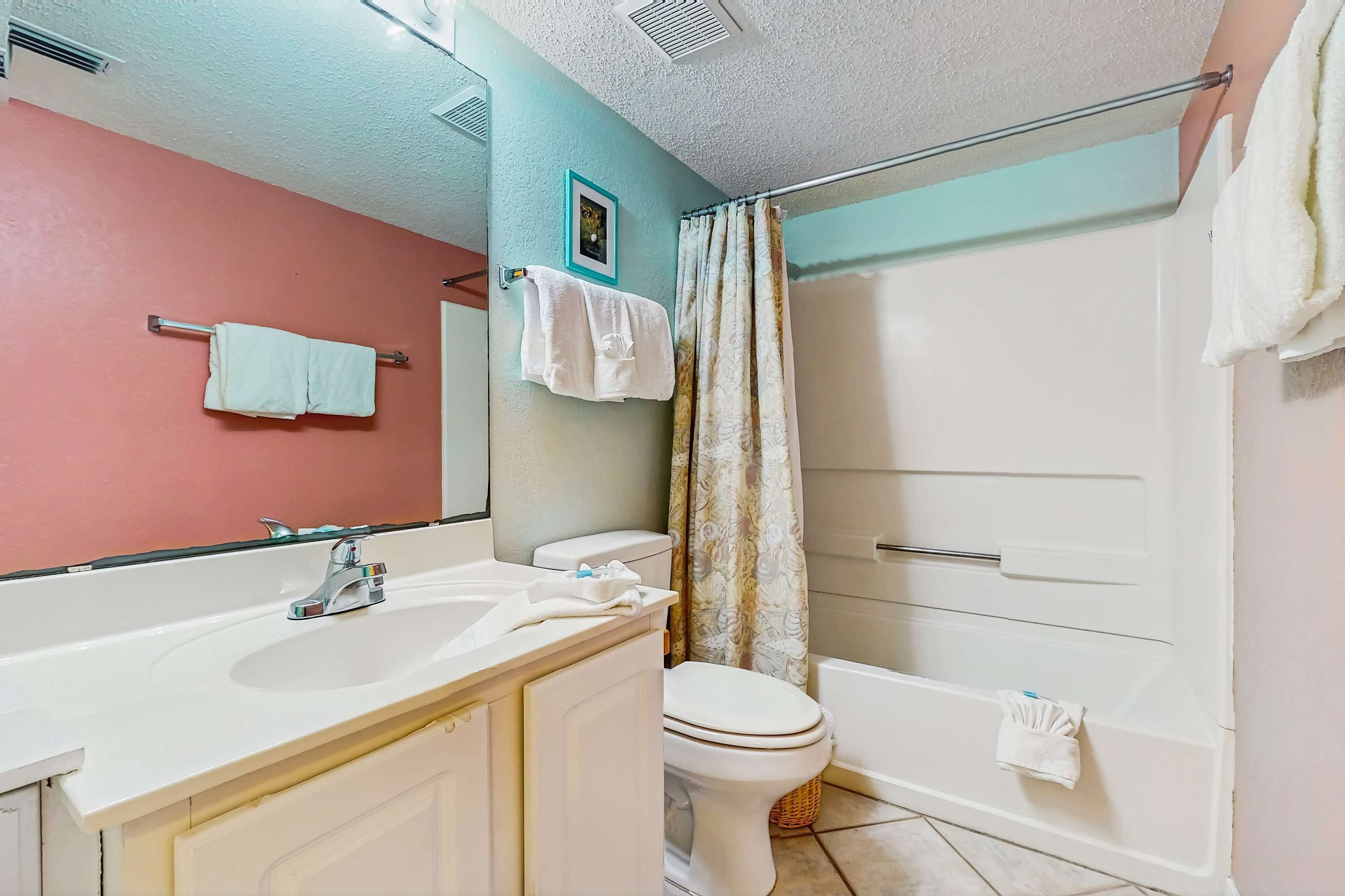 A bathroom with a sink, toilet, and bathtub.
