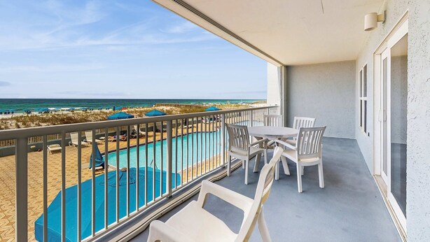 A balcony with a view of a pool and beach. - Beautiful beachfront condo with shared pool & beach access! (Fort Walton Beach)