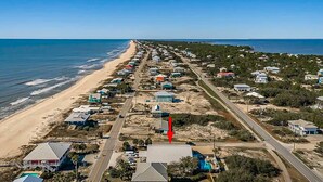 A coastal area with a beach, houses, and a road.